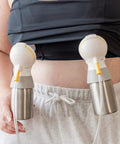Roll Ready Six Oz Stainless Steel Breastmilk Bottle With Direct Pump Setup attached to a pumping device on a nursing mother.