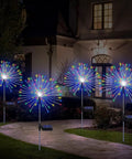 4 Pack Solar Garden Lights With 120 LED Starburst Effects illuminating a courtyard, showing colorful lights and solar panels at night.