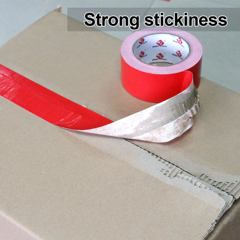 Two Pack Red Duct Tape Heavy Duty 9 Mil Thick 2 Inch By 30 Yard Roll showing strong stickiness on cardboard surface
