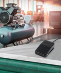Foot Pedal Switch 10A 250V SPDT Momentary Non Slip Plastic Control with Protective Guard FS01 on table in industrial setting