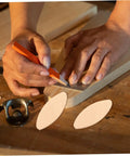 Person marking wood with pencil next to 100 Piece Real Deal Hardwood Joiner Biscuits For Woodworking Board Jointing Straight Up Strong Hold No Hassle Carpenter Kit Badass Quality Smooth Edge Fit Slot Machine Ready Pro Go To Tool.