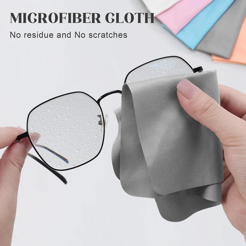 Close-up of gray microfiber glasses cleaning cloth wiping round metal eyeglasses lens