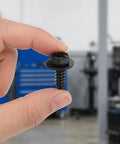 100 Piece Car Body Screw Kit With Integrated Flange Head For Wheel Well Liner And Bumper Cover, Vibration Resistant Auto Body Fasteners, Stable Thread Forming For Easy Disassembly And Reassembly For Your Daily Driver close-up black flange-head screw held by hand