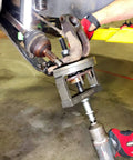 Mechanic using Master Wheel Bearing Removal Tool And Installer Kit with self-centering design on vehicle hub.