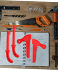 Four piece table saw push stick and block set in red on workbench with tools and sketchbook for ergonomic hand safety and precision cuts