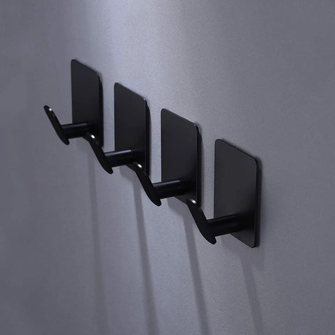 Matte black adhesive hooks 4 pack on wall, ideal for towels, coats, kitchen use. Adhesive Hooks 4 Pack Towel And Coat Hooks For Wall Mounting.