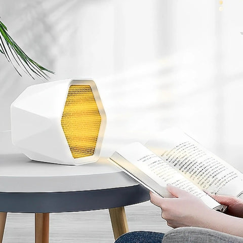 Compact 600W Ceramic Space Heater For Office And Home Hot In No Time Ultra Quiet Mini Desk Heater on table near person reading