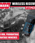 Man using ATV winch with smartphone showing Hub Wireless Receiver for Powersports Winches with Bluetooth Smartphone Control