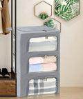 Stacked three pack grab and go clothes storage bins set with stackable foldable organizer boxes sturdy metal frame clear window zipper and label holder odorless eco oxford cloth 22L each gray in bedroom setting.