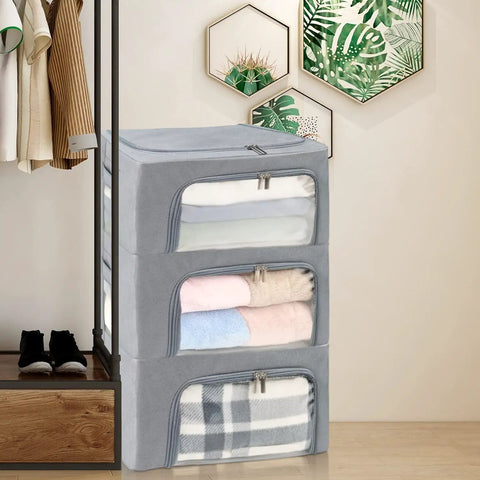 Stacked three pack grab and go clothes storage bins set with stackable foldable organizer boxes sturdy metal frame clear window zipper and label holder odorless eco oxford cloth 22L each gray in bedroom setting.
