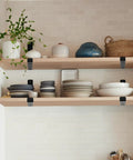 Matte Black J Lip Wall Shelf Brackets Hella Sturdy 8 Pack used to support wooden shelves with dishware and plants.