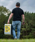 Person carrying 4 Sided Archery Target For Field Points And Broadheads, Open Face Layered Design With Friction Stopping Arrows