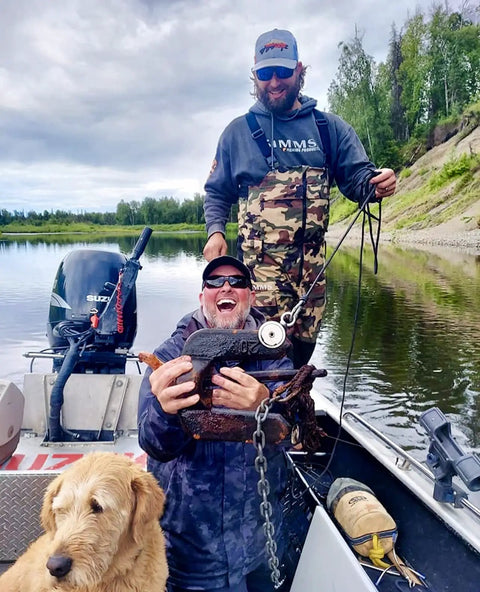 Two men on a boat showing a find using Beefy 1325 Lbs Large Magnet Fishing Kit With Double Sided Neodymium N52 Magnets, dog in foreground.