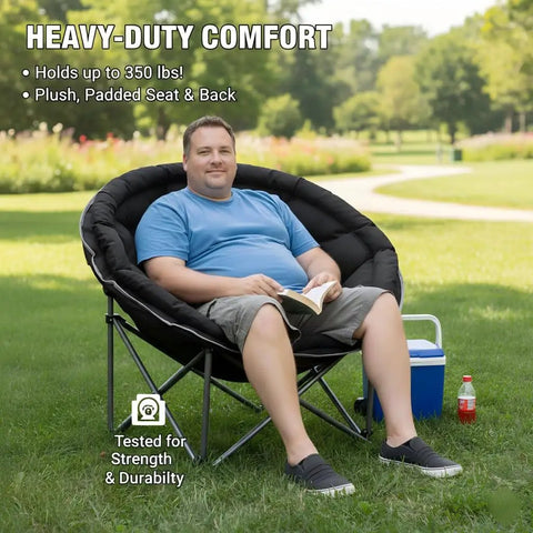 Man relaxing outdoors in XXL Folding Round Camping Chair With Super Cushioned Padded Seat For All Day Comfort Heavy Duty Frame
