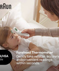 Forehead Digital Thermometer For All Ages Fast Read In Seconds Celsius And Fahrenheit Ergonomic Design Color Coded Temperature Guide Easy To Use For Babies, Kids And Adults. Woman using Braun forehead thermometer on a child in bed