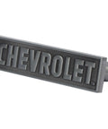 Chevrolet Die Cast Metal Drawer Pull Cabinet Handle For Garage Man Cave Or Shop Vintage Chevy Licensed Hardware In Shiny Black And Silver Finish Collectible, shown in a side angle view.