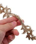 Person holding a Vintage Zinc Alloy Cabinet Handles Set With Antique Silver Finish, showing European style carved detail.