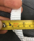 Flat Polyester Pull Tape 3/4 Inch By 100 Feet Packing 2500 Pound Bulletproof Tensile Strength For Conduit And Electrical Wire Running Smooth Non Abrasive Webbing Built Tough For Gritty Job Site Grind measuring tape alongside white polyester webbing.