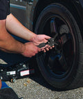Using Heavy Duty Slide Hammer Bearing Puller Kit for quick knock loose of stubborn guide bearings on a vehicle wheel.