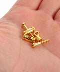 Premium Brass Electric Guitar String Trees Retainers 2 Pairs in hand, golden brass material, used to lock tuner heads down.