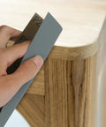 18 Piece Wet Dry Sandpaper Kit 120 To 3000 Grit shown sanding wooden table corner by hand