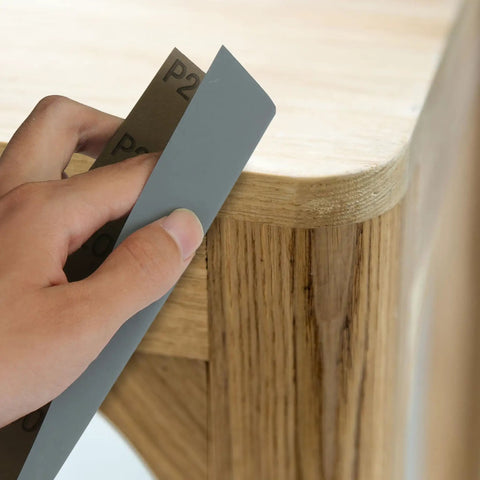 18 Piece Wet Dry Sandpaper Kit 120 To 3000 Grit shown sanding wooden table corner by hand