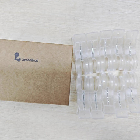 Go-To 10 Pack Large Balloon Arch Clips 3.5 Inch Transparent Spring Clamps beside packaging box on wooden surface