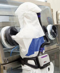 Worker in protective suit using Versaflo TR-6600 Prefilter For TR-600 PAPR Disposable Pack Of 10 That Extends PAPR Life system