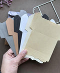 Hand holding various paper cuts from Must Have Envelope Die Set For Scrapbooking And Card Making with Layer Frame Net Metal Cutting Dies.