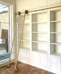 Built Like A Tank Heavy Duty Sliding Ladder Rail Kit With Smooth Carbon Steel Track For Library Loft Spaces Handles Big Loads Up To Three Hundred Thirty Pounds Plus Includes Sturdy Floor Casters on a white bookshelf.