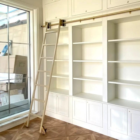 Built Like A Tank Heavy Duty Sliding Ladder Rail Kit With Smooth Carbon Steel Track For Library Loft Spaces Handles Big Loads Up To Three Hundred Thirty Pounds Plus Includes Sturdy Floor Casters on a white bookshelf.