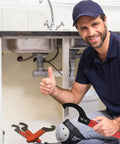 Person holding a 9-Piece Coilover Spanner Wrench from Universal Motorcycle Shock Adjustment Kit with red handle under sink.