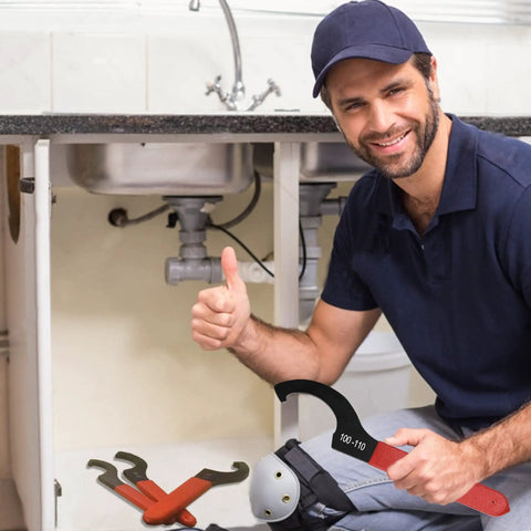 Person holding a 9-Piece Coilover Spanner Wrench from Universal Motorcycle Shock Adjustment Kit with red handle under sink.