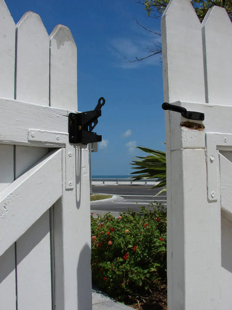 Automatic Gate Latch 4 13/16 Inch Black Steel Self Latching Reversible For Right Or Left Handed Gates mounted on white fence