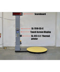 Heavy Duty Industrial Pre Stretch Wrapping Machine With Built In Scale And Thermal Label Printer No Sweat Operation Killer Five Thousand Pound Capacity Straight Shooter Wrap System with yellow turntable and scoreboard.