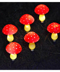 Set of 6 red solar mushroom string lights glowing on grass at night, for Colorful Solar Mushroom String Lights Waterproof Outdoor