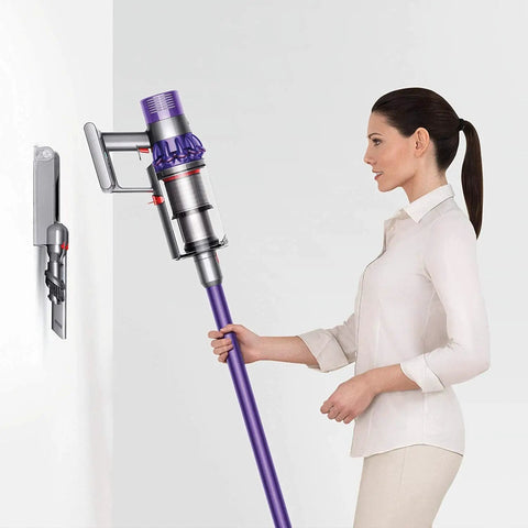 Woman demonstrating Cyclone V10 Animal Cordless Vacuum Cleaner With Quick Release Extension Hose on wall mount