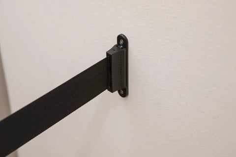Crowd Control Wall Mount Barrier With 8 Foot Black Retractable Belt, Safe Braking System, wall installation close-up