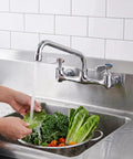 Lead-Free 8 Inch Center Wall Mount 3 Compartment Sink Faucet with 8" Spout washing greens in a utility sink.