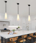 Ziikopoo 2 Pack Modern Matte Black Kitchen Island Pendant Lights, Conical Ribbed Glass Shade above marble countertop in kitchen.