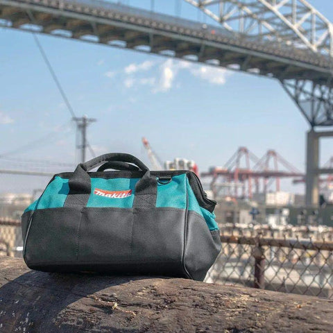 Heavy Duty 14 Inch Contractor Tool Bag with industrial fabric by a worksite bridge with blue sky backdrop