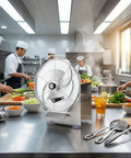 Manual Stainless Steel Slicing Machine with guard plate, baffle, and hand crank on a kitchen counter with chefs prepping food.
