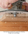Four Piece Chamfer Router Bit Set With Twin Bearing Carbide Edges in use on wood, showing precise bevel cutting action.