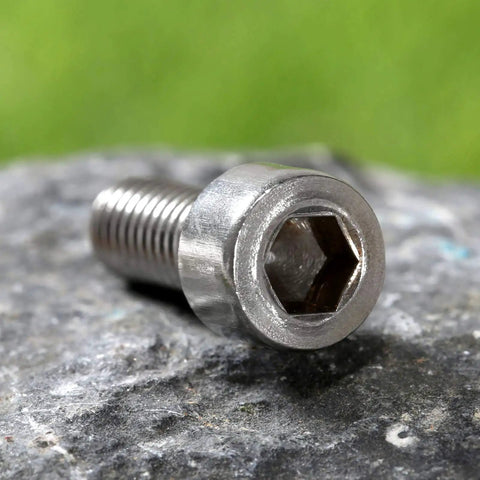 Hex head of 10 Pack M5 Bike Water Bottle Cage Bolts Screws Set Stainless Steel on rock, showing thread and head detail