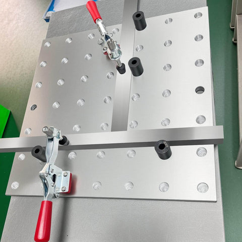 5/8 Inch Insert Clamp Fixture for Welding Tables on benchtop with quick press clamp and sliding jaws, mounted setup visible