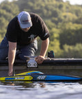 Man preparing Sonicwake RC Boat 48 Inch Self Righting Brushless 8S Ready To Run on dock.