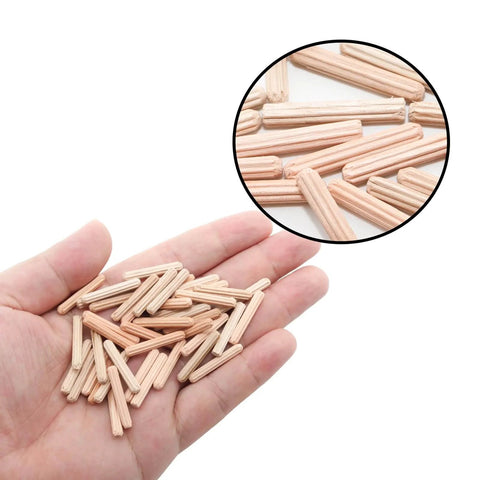 Hand holding 48 pack 4mm by 25mm dowel pins with fluted beveled ends for tight wood joints and shelf support hardwood dowels.