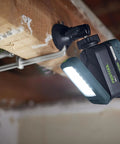 Go Anywhere Cordless Task Light SYSLITE KAL C attached to a wooden beam, illuminating a workspace with bright even light, battery visible