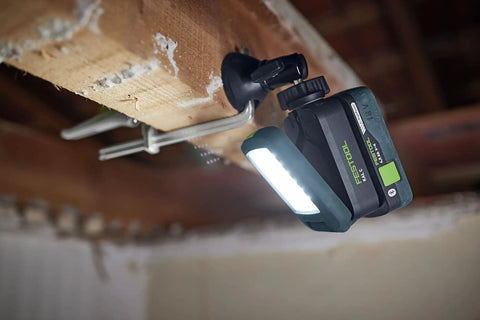 Go Anywhere Cordless Task Light SYSLITE KAL C attached to a wooden beam, illuminating a workspace with bright even light, battery visible