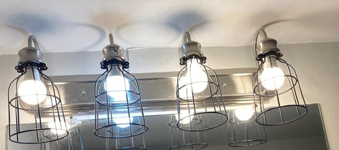 Premium Black Metal Wire Cage Lamp Guard For Ceiling Fans And Pendant Lights Killer Diamond Shape Light Cover With Slick Rust Resistant Coating Set Of Two in use with bulbs.